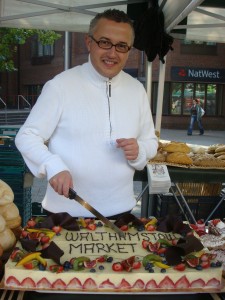 Le Moulin baker with a cake at Walthamstow Farmers market