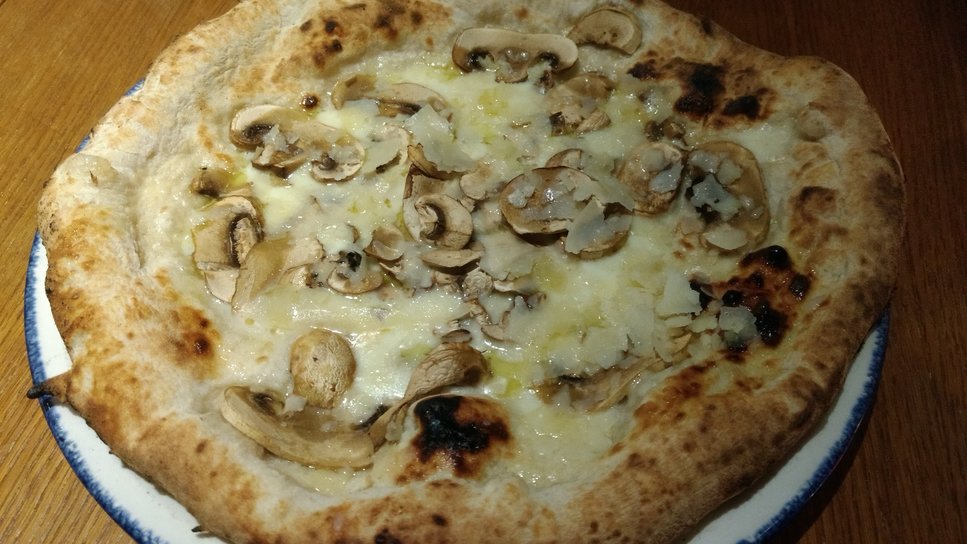 Pizza with mozzarella, mushrooms, shaved parmesan and truffle oil